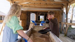 two children panning for gold and holding up fools gold